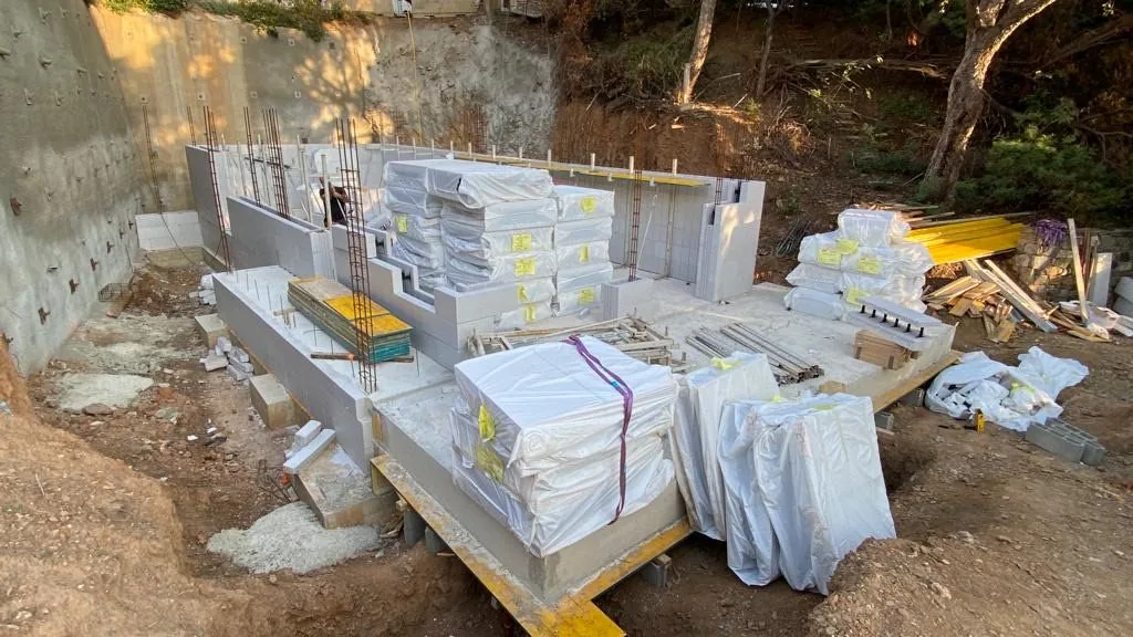 Blocs Reverbloc livres sur palettes au pied du chantier