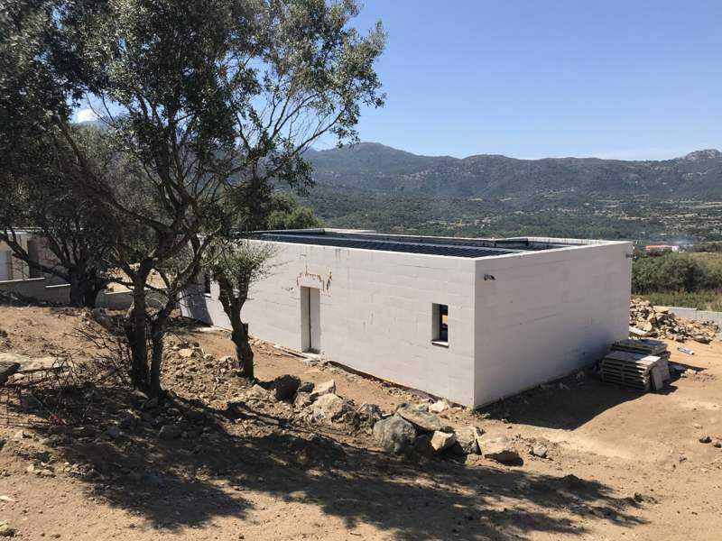 La maison dans son terrain, face aux montagnes.